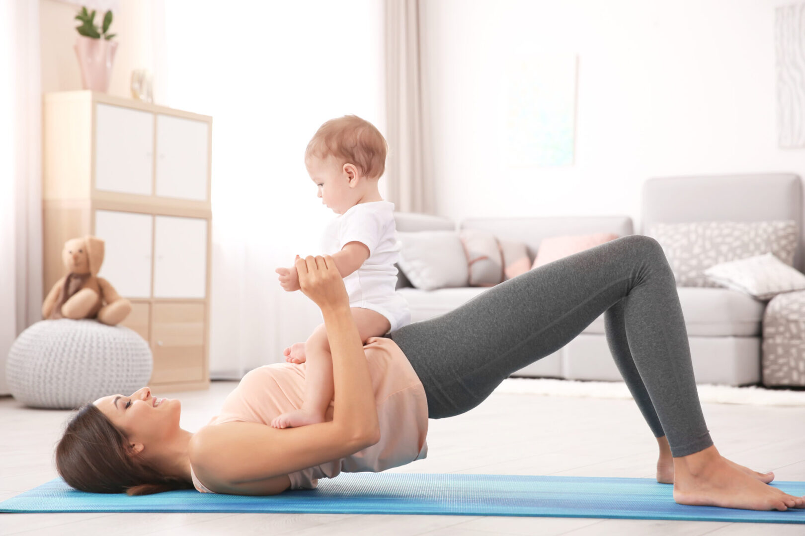 Young mom on floor with baby doing her pelvic floor therapy recommended by Heather at Austin Lymphatic.